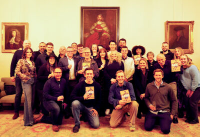 A group of people holding copies of a book and smiling